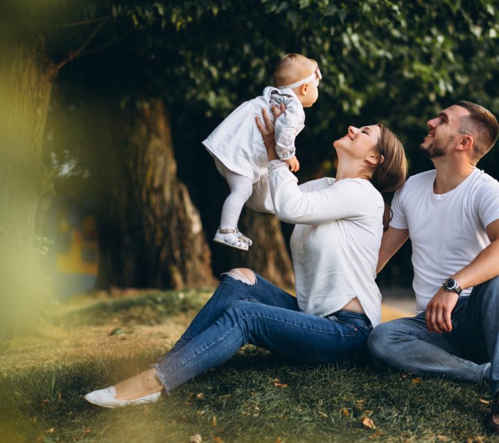 Young family with their small daughter in autumn park